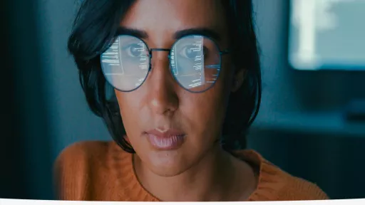 women looking at computer and reflection in her glasses