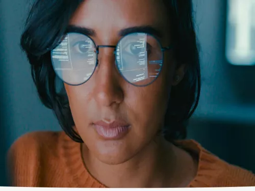 women looking at computer and reflection in her glasses